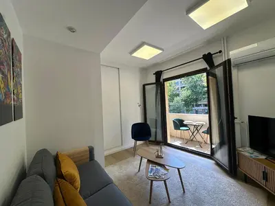a living room with a couch and a tv at L'étape Aixoise - appartement climatisé terrasse centre ville Rotonde cours Mirabeau allées provençales in Aix-en-Provence