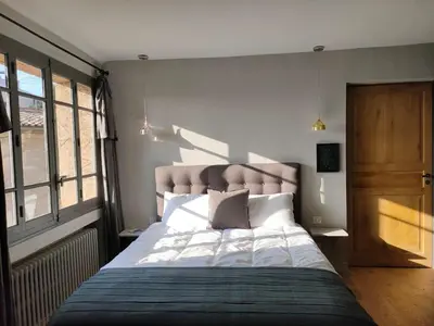 a bedroom with a large bed and a wooden door at Charming house in Provence, 2 to 10 people in Saignon
