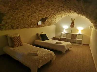 a room with two beds and a table in a cave at Trés jolie bastidon de village in Puyvert