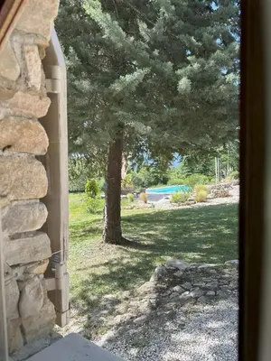 a window view of a yard with a tree at Le Bastidon in Caseneuve