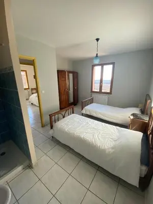 a bedroom with two beds and a bathroom with a sink at Villa de l'Argau in Revest-du-Bion