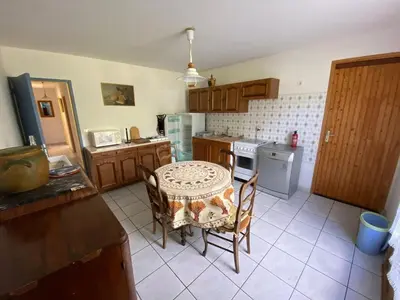 a kitchen with a table and a table and chairs at Villa de l'Argau in Revest-du-Bion