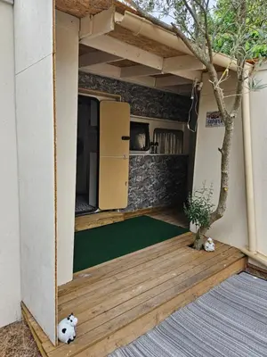 a tiny house with a green carpet on a deck at Escapade en caravane près d'aix en provence in Meyreuil