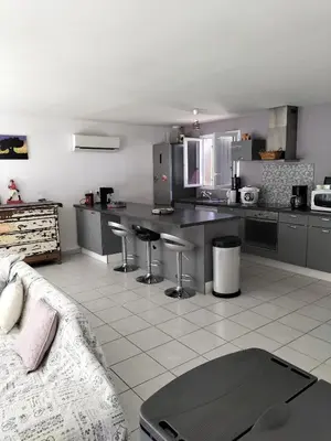 a kitchen with stainless steel appliances and a white tile floor at L infiniment zen in Caromb