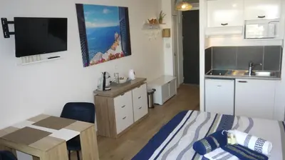 a bedroom with a bed and a table and a kitchen at Studio Business Wi-Fi 7 TVA Proche zones LesMilles La Duranne Aix TGV in Éguilles