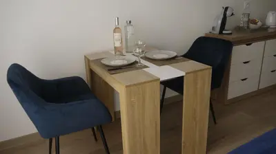 a wooden table with two chairs and a bottle of wine at Studio Business Wi-Fi 7 TVA Proche zones LesMilles La Duranne Aix TGV in Éguilles
