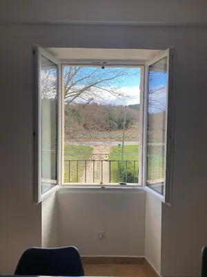 a window in a room with a view of a field at Les Tilleuls in Bonnieux