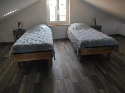 a bedroom with two beds and a window at Les Tilleuls in Bonnieux