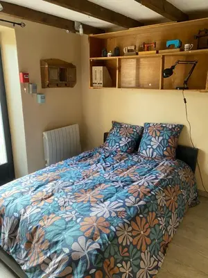 a bedroom with a bed with a colorful comforter at Les terrasses des pourquiers in Gordes