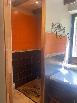 a bathroom with orange and blue tile at Les terrasses des pourquiers in Gordes