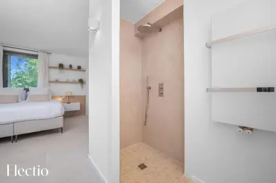a bedroom with a shower and a bedroom with a bed at Domaine Bellevue Ste-Victoire View Pools & Cinema in Le Puy-Sainte-Réparade