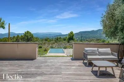 a patio with a couch and a table and a pool at Domaine Bellevue Ste-Victoire View Pools & Cinema in Le Puy-Sainte-Réparade