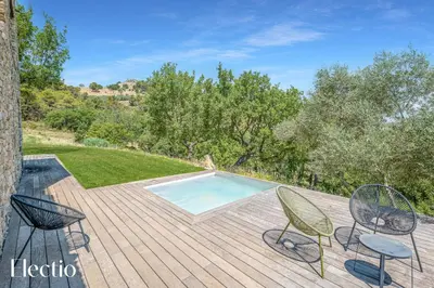 an outdoor deck with chairs and a swimming pool at Domaine Bellevue Ste-Victoire View Pools & Cinema in Le Puy-Sainte-Réparade