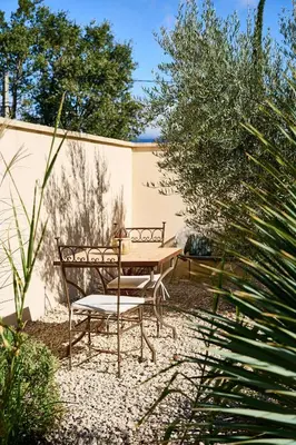 a wooden table and chairs in a garden at Maison au calme proche Mont Ventoux et Luberon in Malemort-du-Comtat