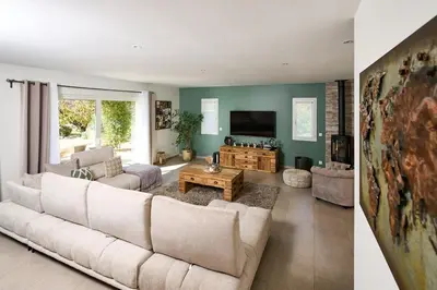 a living room with a white couch and a tv at Maison au calme proche Mont Ventoux et Luberon in Malemort-du-Comtat