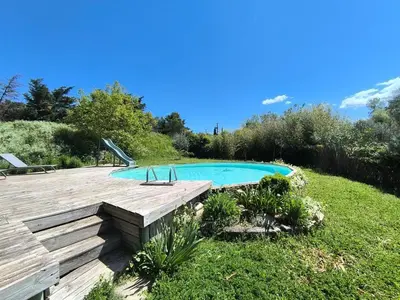 a swimming pool in a yard with a wooden deck at Gîte en Provence in Cavaillon