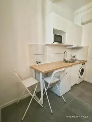 a white bedroom with a bed and a table at New - studio avec clim au centre d'Aix 2eme étage in Aix-en-Provence