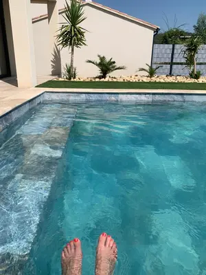 a person is standing in a swimming pool at Villa MTI Ventoux in Blauvac