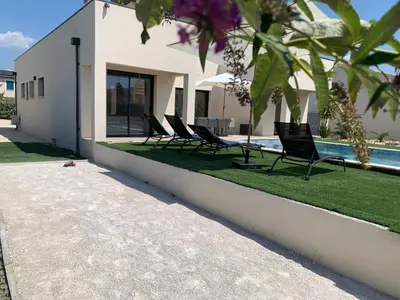 a row of chairs sitting next to a swimming pool at Villa MTI Ventoux in Blauvac
