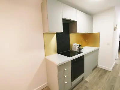 a small kitchen with white cabinets and a counter top at Studio plein centre Aix-en-Provence in Aix-en-Provence