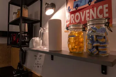 a shelf with jars and a roll of paper towels at Un Loft en Luberon à Bonnieux in Bonnieux