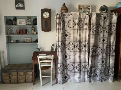 a dining room with a table and a curtain at Le Yodala - Lamanon in Lamanon