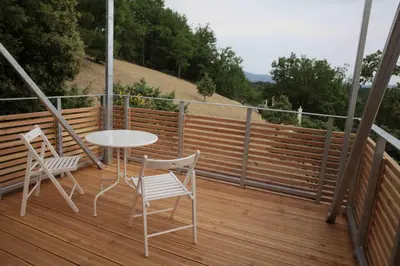 a table and two chairs on a wooden deck at La Source in Saint-Saturnin-les-Apt