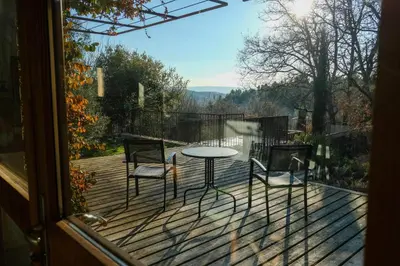 a balcony with a table and chairs on a deck at La Source in Saint-Saturnin-les-Apt