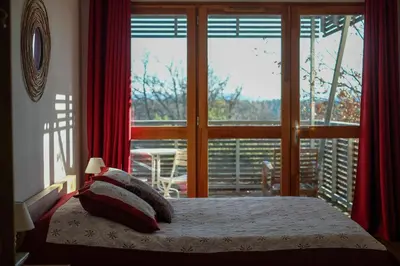 a bedroom with a bed and a large window at La Source in Saint-Saturnin-les-Apt