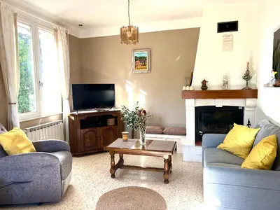 a living room with two couches and a tv at La maison aux oiseaux - Luberon in Oppède