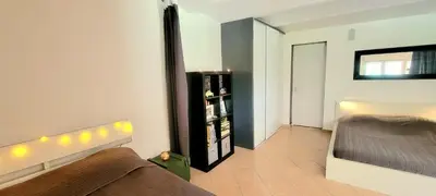 a bedroom with a bed and a shelf with bottles at Appartement au calme à 5min du centre d'Aix-en-Provence avec terrasse vue sur jardin & parking privé in Aix-en-Provence