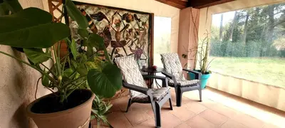 a porch with two chairs and a table and a plant at Appartement au calme à 5min du centre d'Aix-en-Provence avec terrasse vue sur jardin & parking privé in Aix-en-Provence