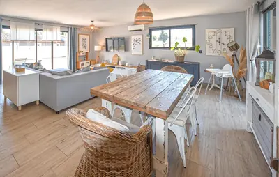 a kitchen and living room with a wooden table and chairs at Maison Avec Piscine Privée in Monteux