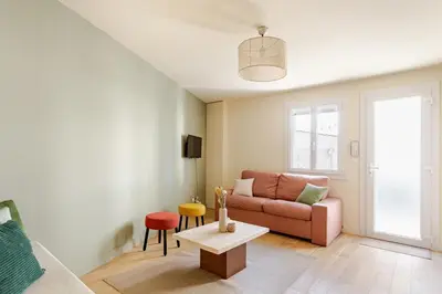 a living room with a pink couch and a table at Cocoon et style - proche du centre in Aix-en-Provence