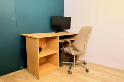 a wooden desk with a computer monitor and a chair at Cocoon et style - proche du centre in Aix-en-Provence