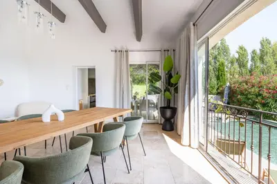 a dining room with a table and chairs and a balcony at Villa Sun7 in Crillon-le-Brave