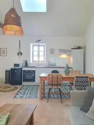a living room with a table and a kitchen at Maison Grand Rue - Vue Exceptionnelle sur le Luberon in Lauris