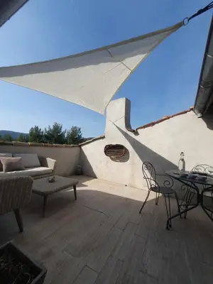 a patio with a table and chairs and a couch at Maison Grand Rue - Vue Exceptionnelle sur le Luberon in Lauris