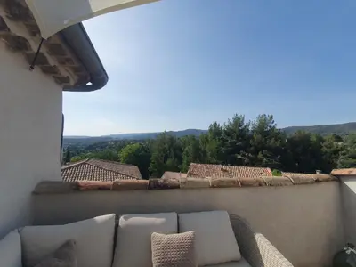 a couch sitting on a balcony with a view at Maison Grand Rue - Vue Exceptionnelle sur le Luberon in Lauris