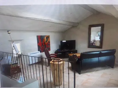 a living room with a couch and a table at Superbe appartement au pied du Mont Ventoux in Caromb