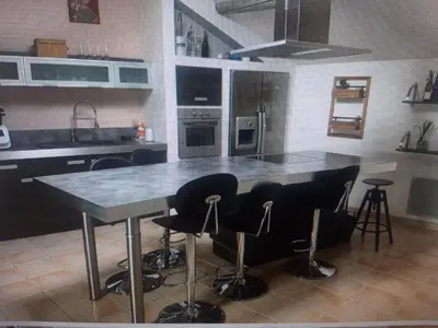 a kitchen with a table and bar stools at Superbe appartement au pied du Mont Ventoux in Caromb