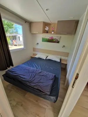 a bed in a small room with a window at Mobil home en Provence - Camping 4 étoiles- 2 chambres -4 à 6 pers-clim-terrasse-TV in Cadenet