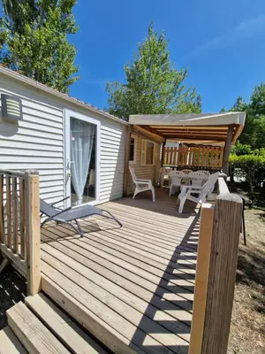 a wooden deck with a table and chairs on it at Mobil home en Provence - Camping 4 étoiles- 2 chambres -4 à 6 pers-clim-terrasse-TV in Cadenet