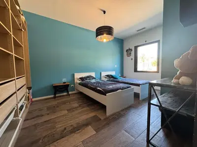 a bedroom with two beds and a blue wall at Villa Cali-Provence in Le Puy-Sainte-Réparade