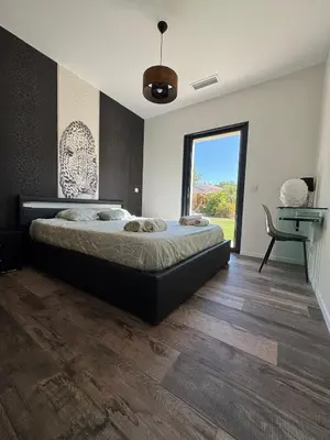 a bedroom with a large bed and a large window at Villa Cali-Provence in Le Puy-Sainte-Réparade