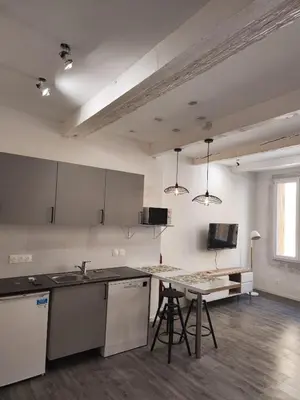 an empty kitchen with a counter and a table at Aix Centre-ville in Aix-en-Provence