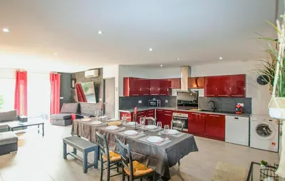 a kitchen and living room with a table and red cabinets at Awesome Home In Morières Les Avignon in Morières-lès-Avignon