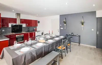 a kitchen with a long table with chairs and red cabinets at Awesome Home In Morières Les Avignon in Morières-lès-Avignon