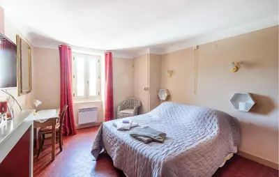 a bedroom with a bed and a table and a window at 3 Bedroom Stunning Home In Saignon in Saignon
