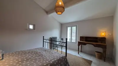 a bedroom with a bed and a desk and a piano at La maison Calavoun in Maubec
